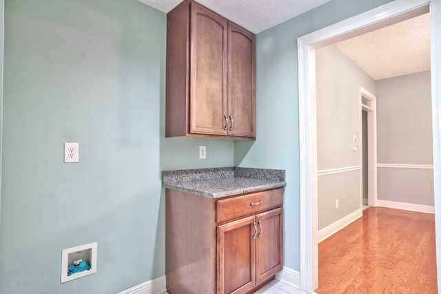 kitchen with light hardwood / wood-style floors and a textured ceiling