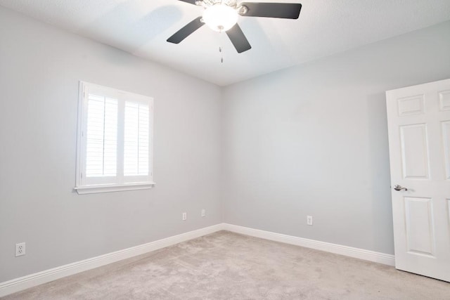 spare room with light colored carpet and ceiling fan