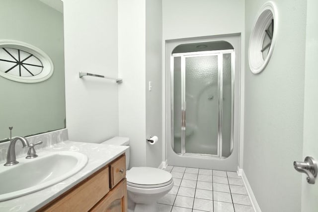 bathroom featuring tile patterned flooring, vanity, a shower with shower door, and toilet