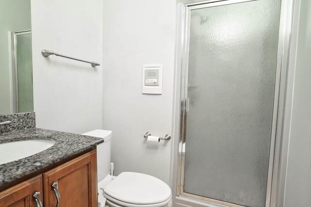 bathroom featuring walk in shower, vanity, and toilet