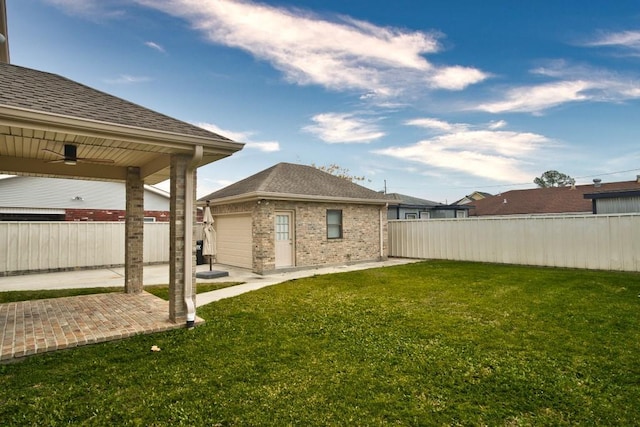 view of yard with ceiling fan, an outdoor structure, and a patio