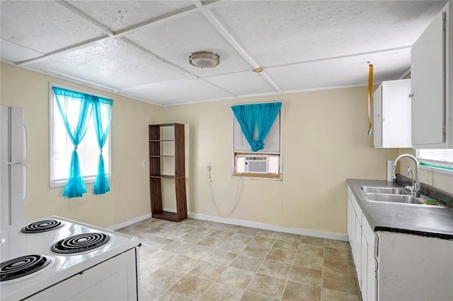 kitchen featuring stove, cooling unit, sink, white refrigerator, and white cabinetry