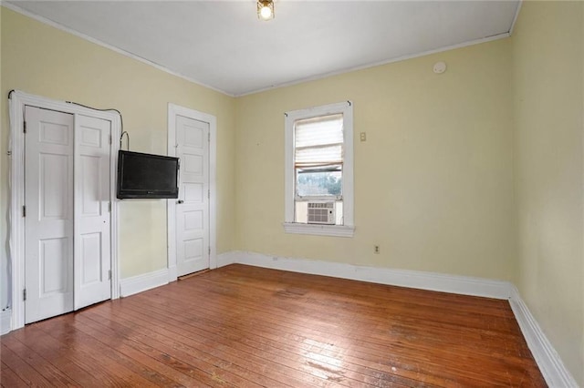 unfurnished bedroom with hardwood / wood-style flooring and cooling unit