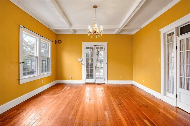 spare room with beamed ceiling, a chandelier, and coffered ceiling