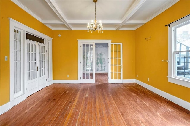 empty room featuring coffered ceiling, beam ceiling, and french doors