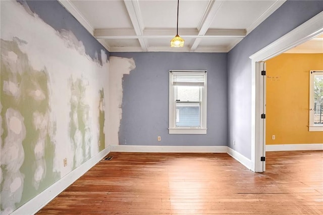 unfurnished room featuring beamed ceiling, wood-type flooring, a wealth of natural light, and coffered ceiling