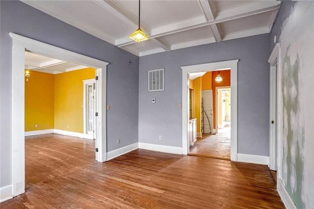 spare room with beamed ceiling, hardwood / wood-style flooring, and coffered ceiling