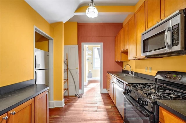 kitchen featuring appliances with stainless steel finishes, dark hardwood / wood-style flooring, and sink