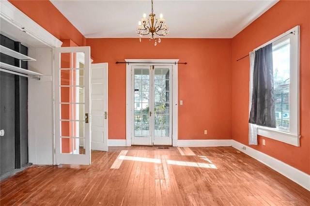 doorway featuring french doors, an inviting chandelier, and hardwood / wood-style flooring