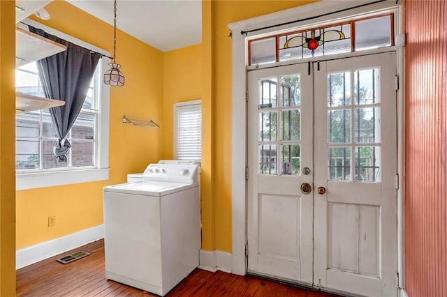 laundry area featuring hardwood / wood-style floors, a healthy amount of sunlight, and washer / dryer