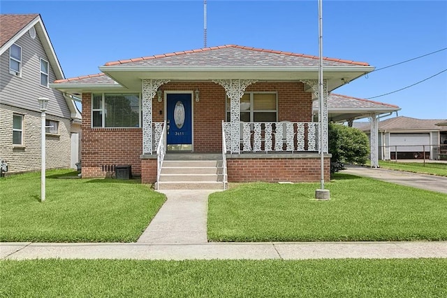 bungalow-style home featuring covered porch, brick siding, and a front lawn