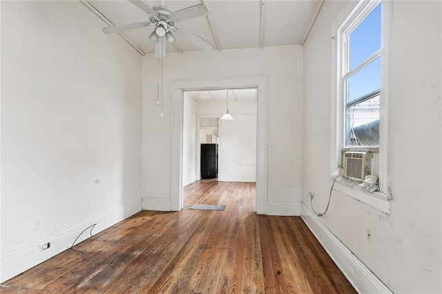 empty room with cooling unit, ceiling fan, and dark wood-type flooring