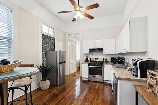 kitchen featuring appliances with stainless steel finishes, sink, white cabinets, dark hardwood / wood-style floors, and plenty of natural light