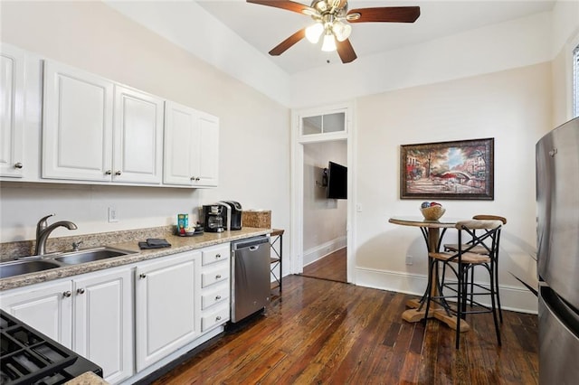 kitchen featuring dark hardwood / wood-style flooring, stainless steel appliances, ceiling fan, sink, and white cabinets