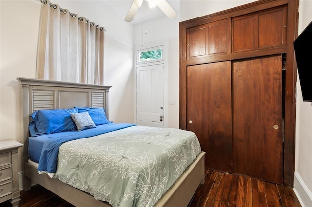 bedroom featuring ceiling fan, dark hardwood / wood-style flooring, and a closet