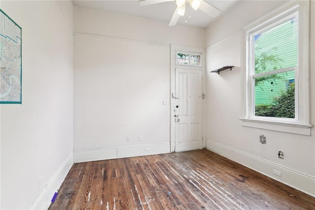 unfurnished room featuring ceiling fan, a healthy amount of sunlight, and dark hardwood / wood-style floors