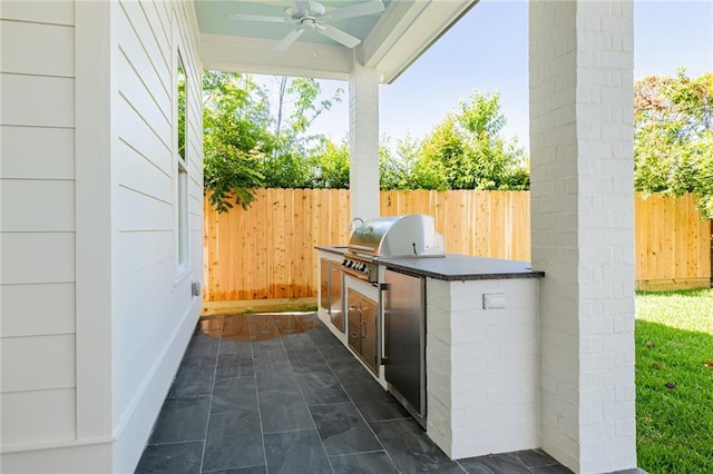 view of patio / terrace with area for grilling, ceiling fan, and exterior kitchen