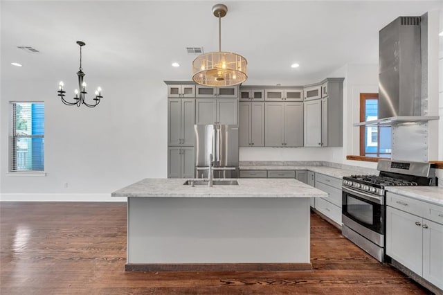 kitchen featuring ventilation hood, decorative light fixtures, stainless steel appliances, and an island with sink