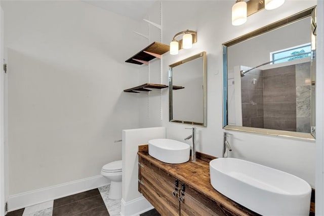 bathroom with a shower, vanity, tile patterned floors, and toilet