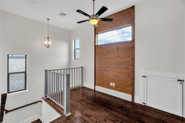 entrance foyer featuring ceiling fan with notable chandelier and dark hardwood / wood-style floors