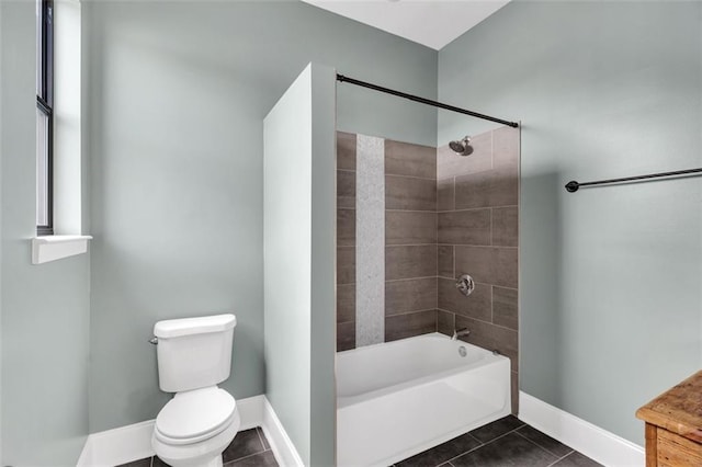 bathroom with tile patterned floors, tiled shower / bath combo, and toilet