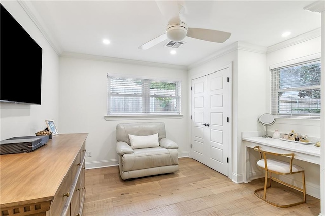 interior space featuring ceiling fan, light wood-type flooring, and crown molding