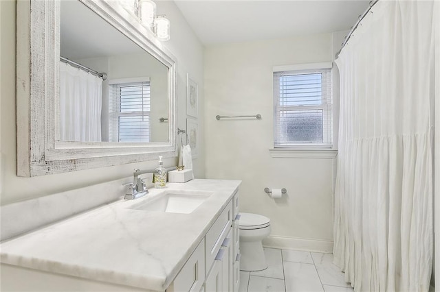 bathroom featuring vanity, a healthy amount of sunlight, and toilet