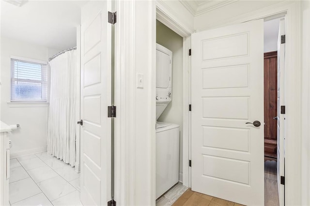 interior space with crown molding and stacked washer and clothes dryer