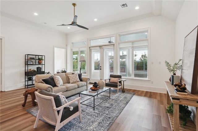 living room with hardwood / wood-style flooring, ceiling fan, and crown molding