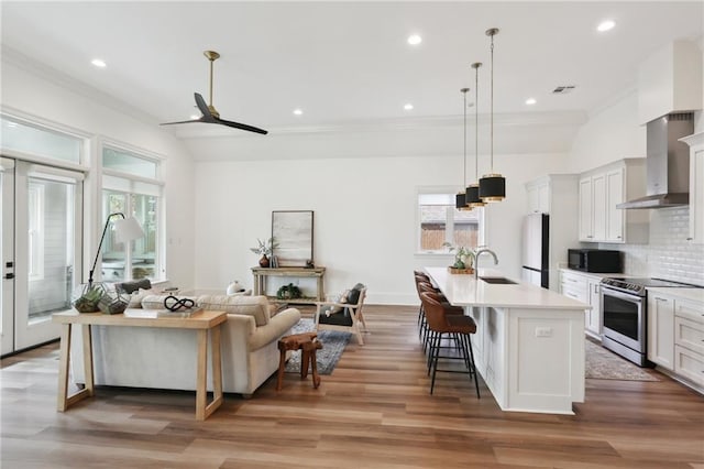 living room with a healthy amount of sunlight, sink, wood-type flooring, and lofted ceiling