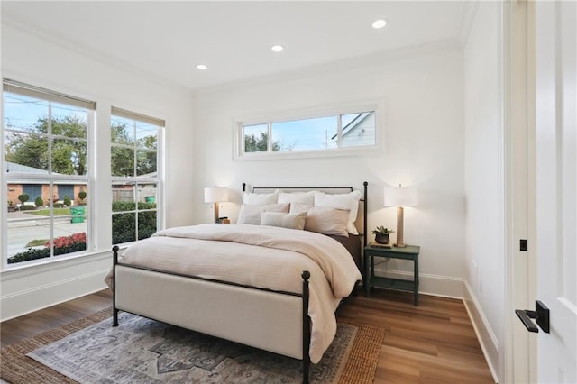 bedroom featuring multiple windows, hardwood / wood-style floors, and ornamental molding