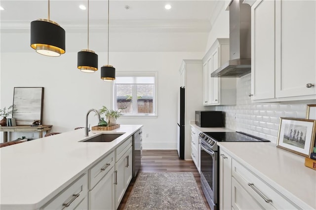 kitchen with a kitchen island with sink, white cabinets, sink, wall chimney exhaust hood, and appliances with stainless steel finishes