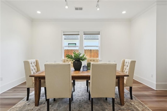 dining area featuring wood-type flooring and ornamental molding