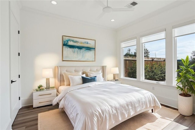 bedroom featuring ceiling fan, dark hardwood / wood-style floors, and multiple windows