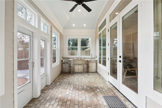 unfurnished sunroom with ceiling fan, lofted ceiling, sink, and french doors