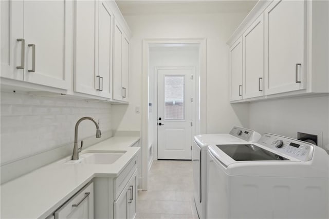 washroom featuring cabinets, washer and clothes dryer, and sink