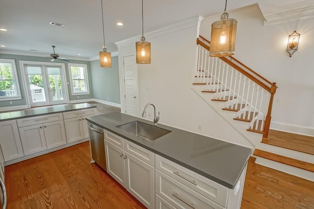 kitchen featuring sink, crown molding, hanging light fixtures, dishwasher, and hardwood / wood-style floors