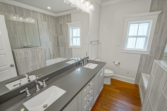 full bathroom with hardwood / wood-style flooring, ornamental molding, vanity,  shower combination, and toilet