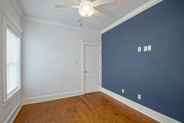 unfurnished room featuring hardwood / wood-style floors, a wealth of natural light, ornamental molding, and ceiling fan