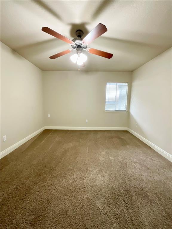 empty room with ceiling fan and carpet floors