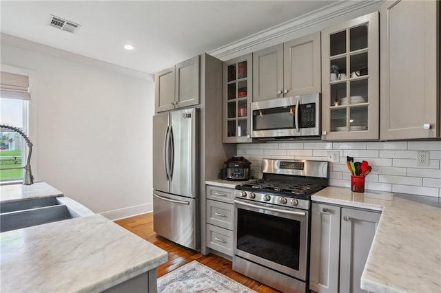 kitchen with gray cabinetry, visible vents, tasteful backsplash, and appliances with stainless steel finishes