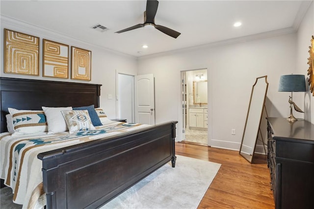 bedroom with light wood-type flooring, visible vents, crown molding, and baseboards