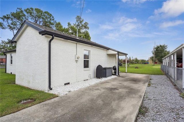 view of side of home featuring crawl space, roof with shingles, a lawn, and brick siding