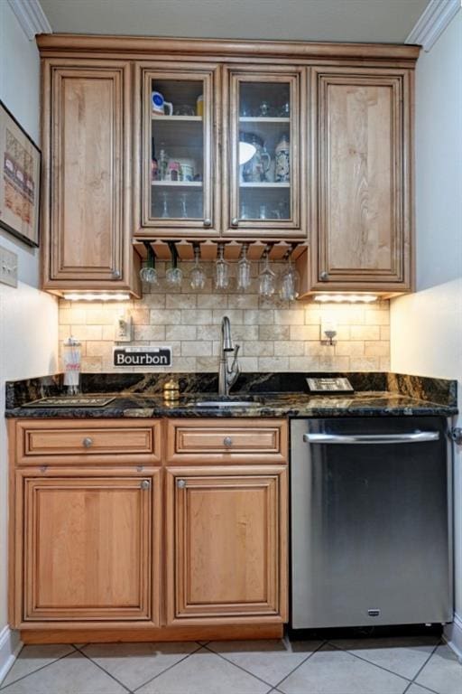 bar with dark stone counters, dishwasher, decorative backsplash, and light tile patterned floors