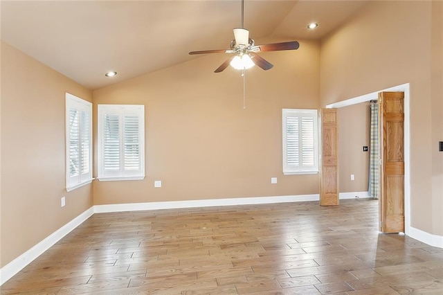 spare room with light hardwood / wood-style floors, ceiling fan, and high vaulted ceiling