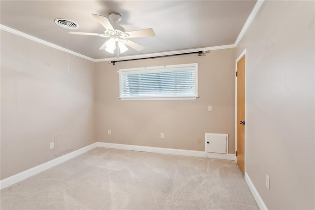 spare room featuring ceiling fan, crown molding, and light colored carpet