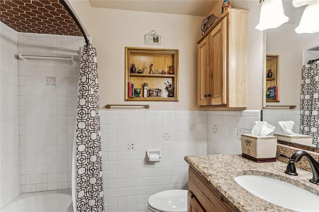 full bathroom with tile walls, toilet, shower / bath combination with curtain, vanity, and built in shelves