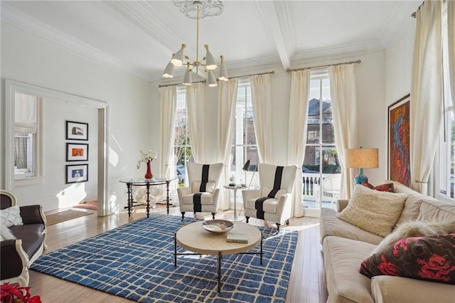 sitting room with beam ceiling, hardwood / wood-style floors, ornamental molding, and an inviting chandelier