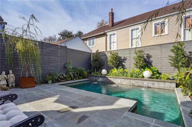 view of swimming pool with pool water feature and a patio