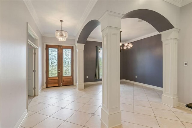 entrance foyer featuring a notable chandelier, ornate columns, crown molding, and french doors